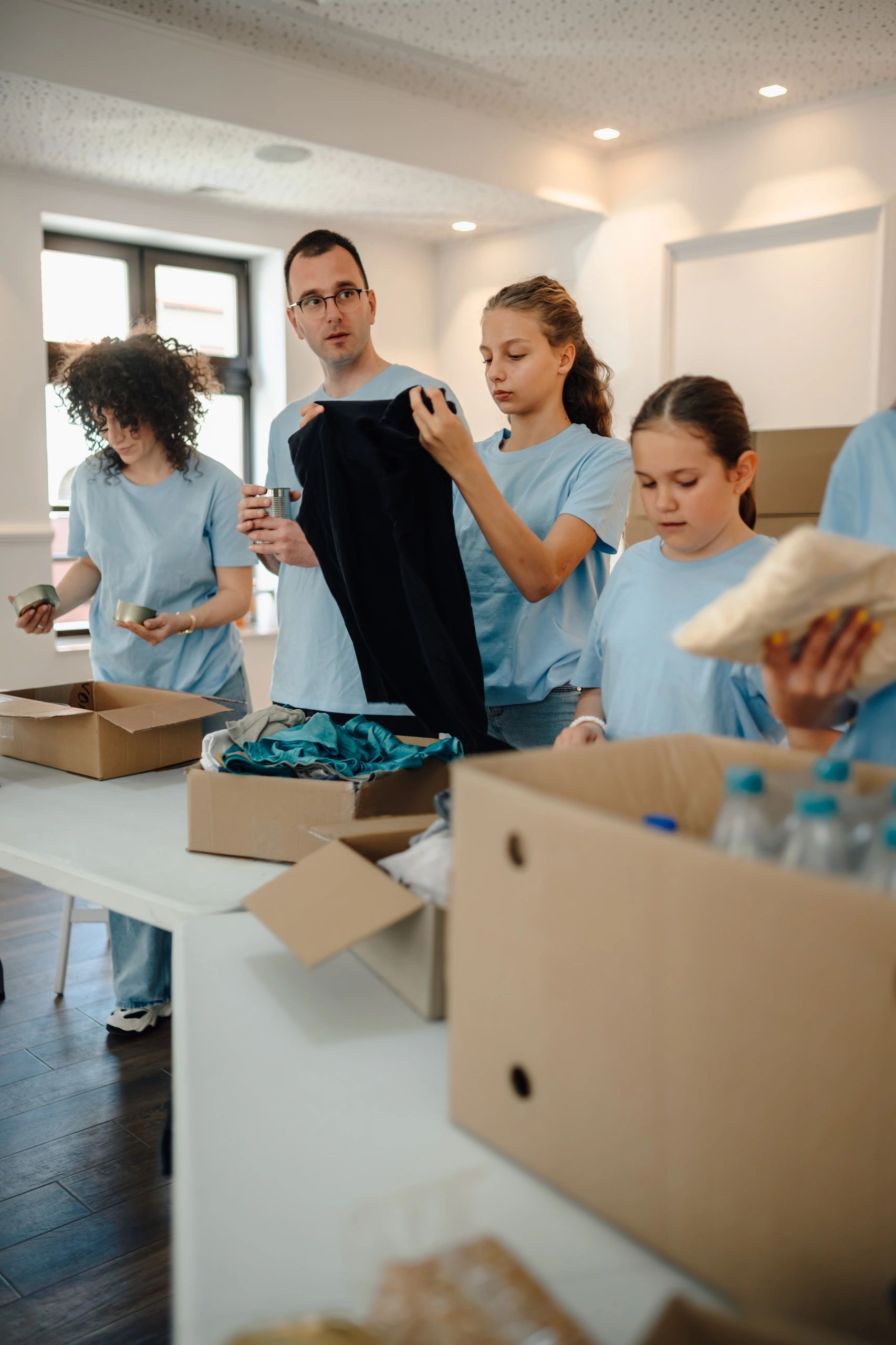 Volunteers packing donation boxes with clothes and food