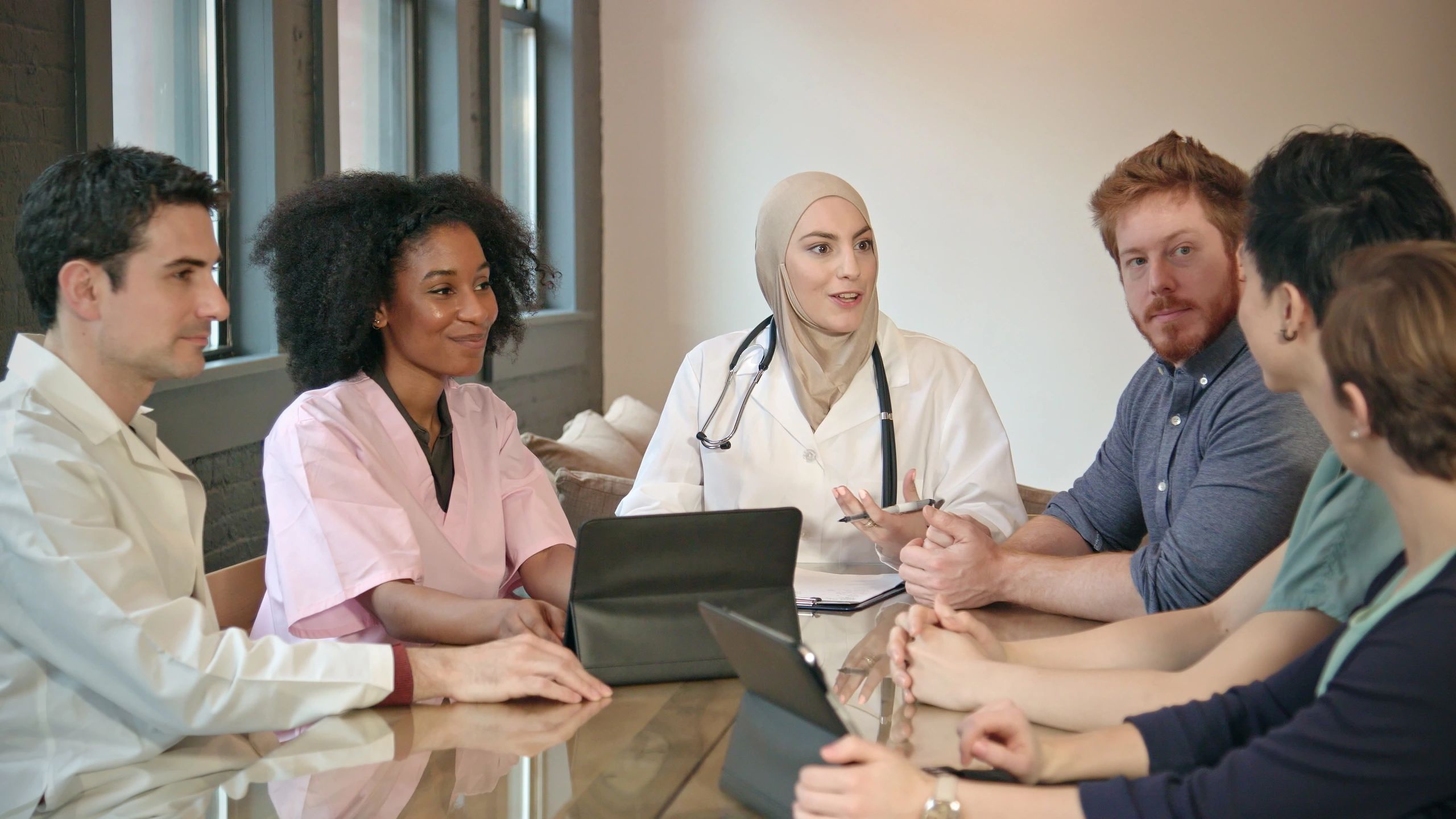 Multi-ethnic medical team led by a doctor in a modern office